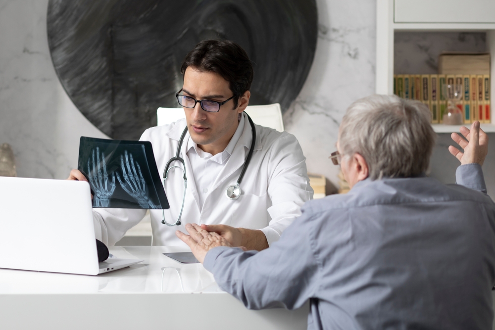 A doctor discussing an arthritis diagnosis with a patient. Image by Vitaliy Abbasov via Shutterstock.