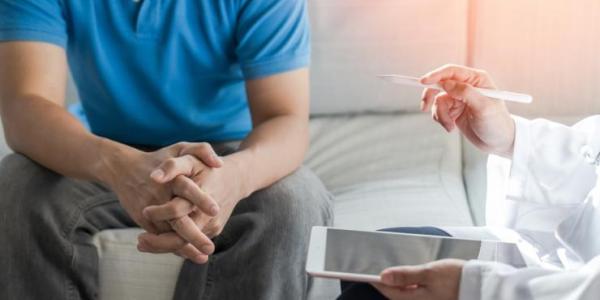 A patient discussing treatment plans with his doctor. Image credit: Chinnapong via Shutterstock.