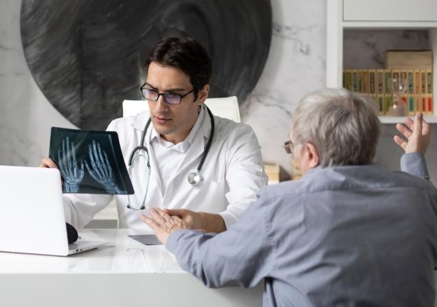 A doctor discussing an arthritis diagnosis with a patient. Image by Vitaliy Abbasov via Shutterstock.