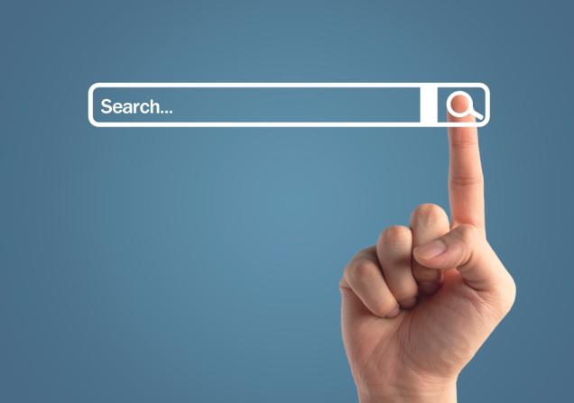 The index finger of a person clicking on a search button next to a search bar. Image by 19 Studio via Shutterstock.