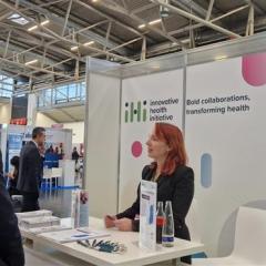 Image of an IHI staff member welcoming people at the booth