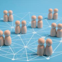 Pairs of wooden figures on a network pattern. Image via Shutterstock