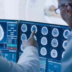 Image by Gorodenkoff via Shutterstock. Medical staff discussing a brain scan on a computer screen. Image by Gorodenkoff via Shutterstock.